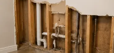 Exposed studs and plumbing after a wall leak